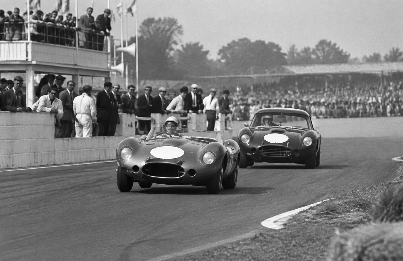 Two racing cars at a British circuit in the 1960s